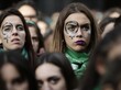 Zwei Frauen mit einem aufgemalten Venussymbol auf dem Gesicht.